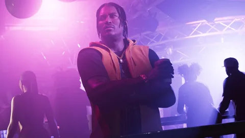 Dre’Quan Priest au milieu d’un club baigné de lumière violette, visuel officiel Rockstar Games