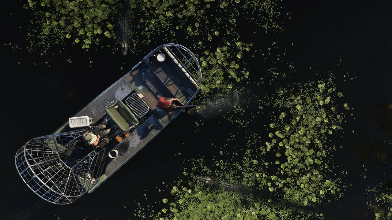 Vu du ciel, deux hommes en hydroglisseur au milieu des alligators, l’un vise le plus proche, capture officielle de GTA VI
