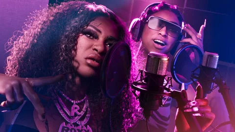 Les deux rappeuses de Real Dimez au micro dans une cabine d’enregistrement, casques sur les oreilles, visuel officiel Rockstar Games