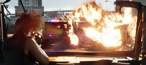Lucia tire au lance-grenades depuis un véhicule pendant une poursuite, photogramme du Trailer 2 vers 1:58