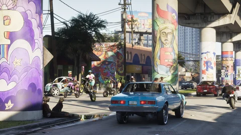 Un chien noir assis contre une personne au pied d’un pilier peint, sous le viaduc de Vice City, pendant que des motos font des roues arrière, capture officielle Rockstar Games